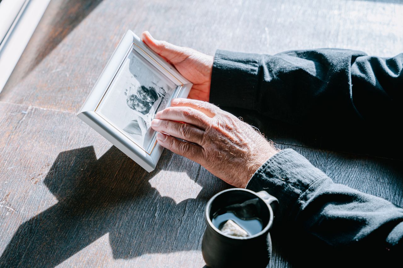 Hands holding a photo frame, symbolizing remembrance and nostalgia.
